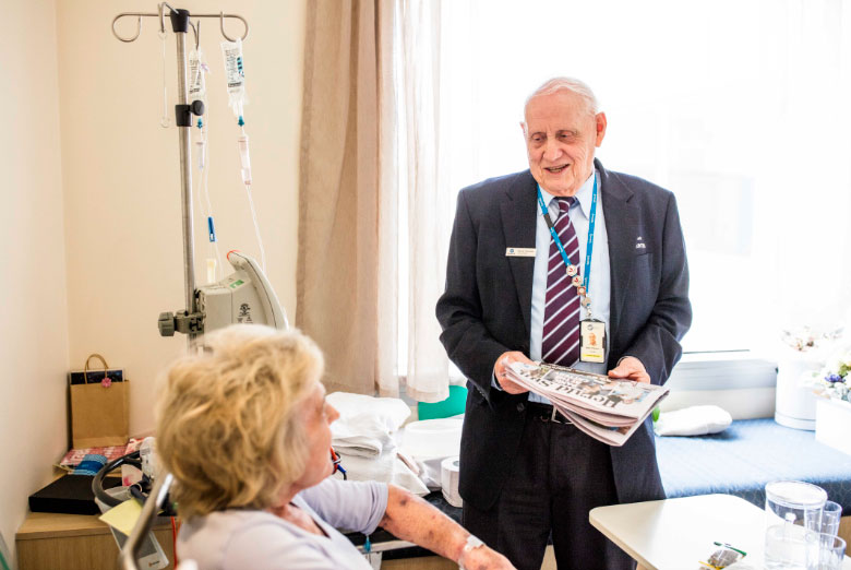 Mario Pianezze delivers the daily newspaper to patients on the ward at Eastern Box Hill